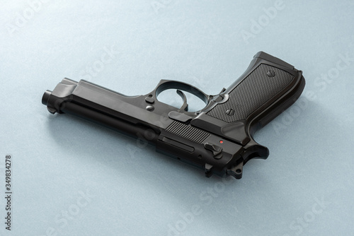 Black pistol gun isolated on the blue background. photo