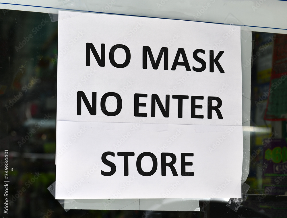 Warning sign to customers that a face mask is required to enter retail store due to COVID-19 coronavirus pandemic