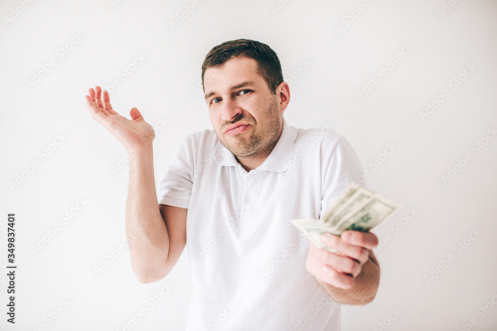 Young man isolated over white background. Guy wonder holding one hand a bit up. Bills money in another hand. Given cash. Young man isolated over white background. Guy wonder holding one hand a bit up. Bills money in another hand. Given cash.
