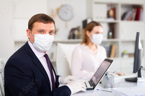 Portrait of businessman in protective medical mask at office