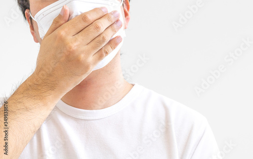 白いマスクをつけ、咳をする男性
