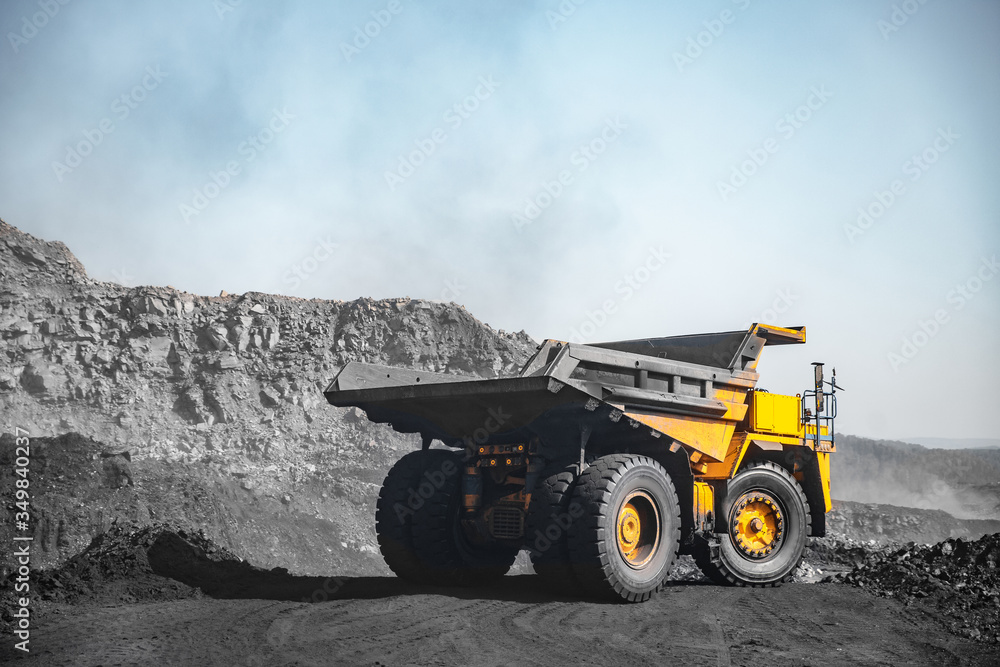 Open pit mine industry. Yellow mining truck for coal move to excavator loads