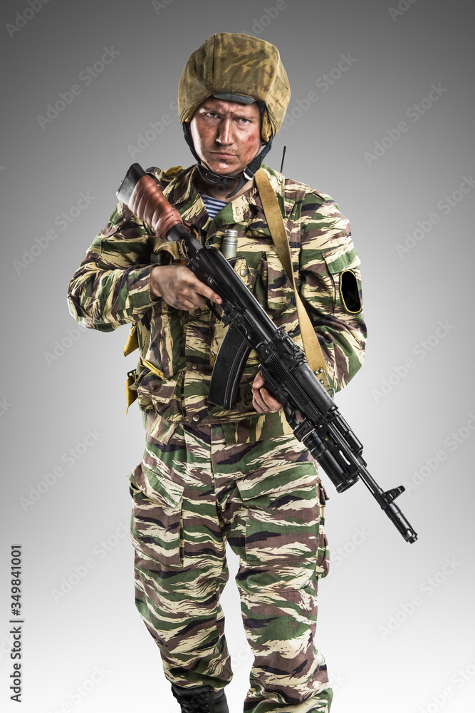 Male in uniform conforms to Russian army special forces (OMON) in War in Chechnya. Isolated on grey background Male in uniform conforms to Russian army special forces (OMON) in War in Chechnya. Isolated on grey background