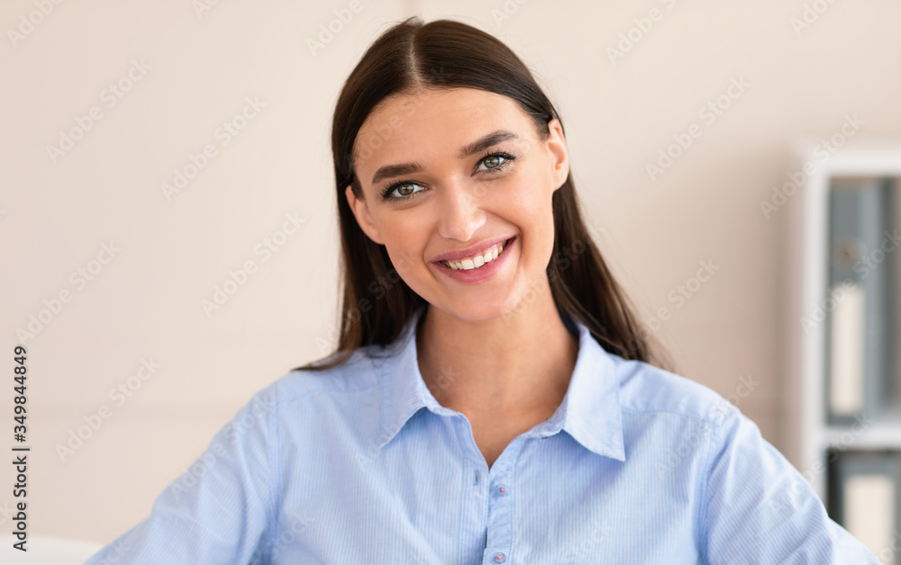 Young Businesswoman Smiling To Camera Posing At Workplace In Office Young Businesswoman Smiling To Camera Posing At Workplace In Office
