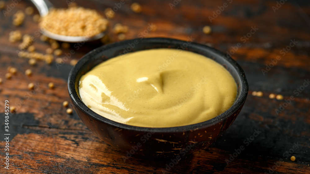 Dijon mustard in bowl on wooden table. Dijon mustard in bowl on wooden table.