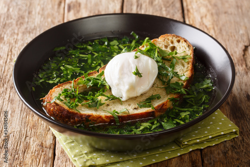 Summer Acorda Soup with cilantro, garlic, homemade bread and poached egg close-up in a plate. horizontal photo