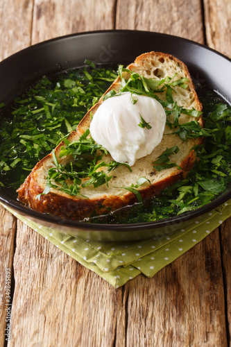 Acorda soup of the Alentejo region of Portugal. It is prepared with eggs, bread, olive oil, garlic and cilantro close-up in a plate. Vertical photo