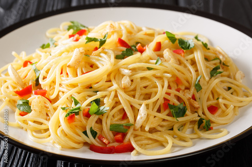 Spaghetti aglio e olio Italian for spaghetti with garlic and oil is a traditional pasta dish from Naples close-up in a plate. Horizontal