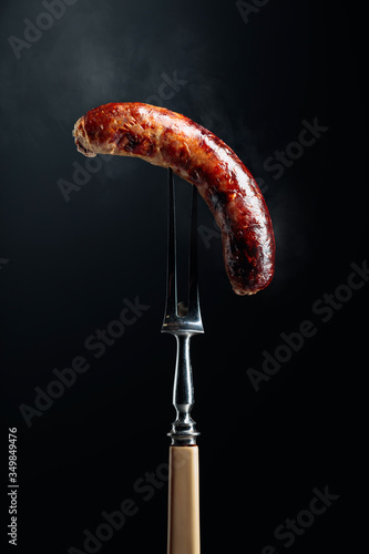 Grilled Bavarian sausage on a fork.