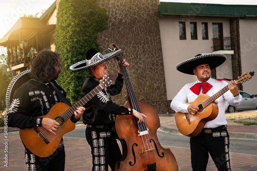Mexican musicians play musical instruments in the city. City street in the summer. © scharfsinn86
