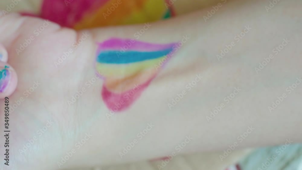 Pride day. Female drawing a rainbow flag on her nails. LGBTQ style nail art and body art. Pride festival 2020. Human rights, gender equality concepts Pride day. Female drawing a rainbow flag on her nails. LGBTQ style nail art and body art. Pride festival 2020. Human rights, gender equality concepts