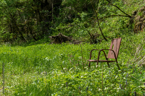 Alter, verrosteter Stuhl inmitten auf einer Almwiese bei einer Wanderung
