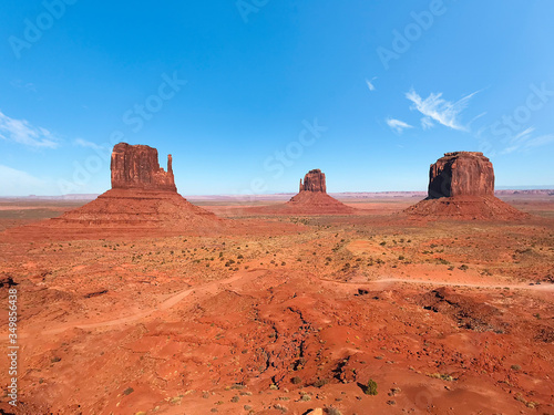 Amazing view of Monument Valley with red desert and blue sky and clouds in the morning. Monument Valley in Arizona with West Mitten Butte  East Mitten Butte  and Merrick Butte. 