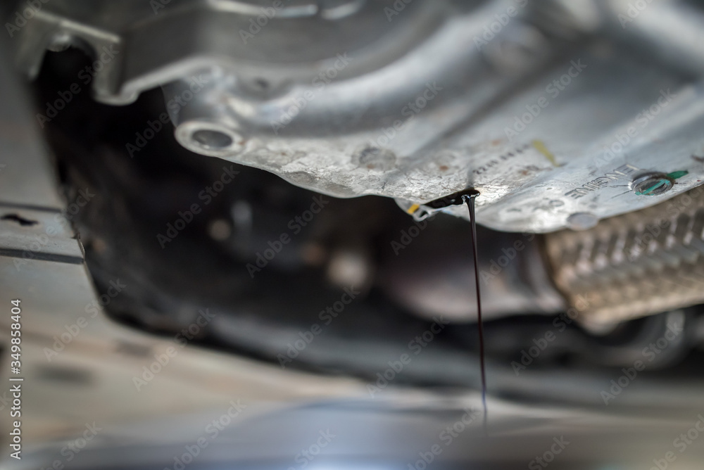 Drain the old oil from the engine through the drain plug. Changing the oil in a car engine. Drain the old oil from the engine through the drain plug. Changing the oil in a car engine.