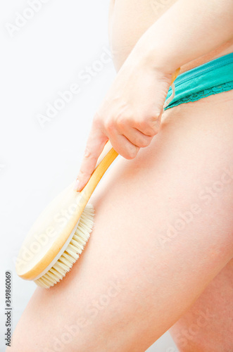 Dry massage. Massage at home, in the salon with a brush of natural bristles. Girl does massage legs, buttocks in macro standing front and side. Girl in green underwear