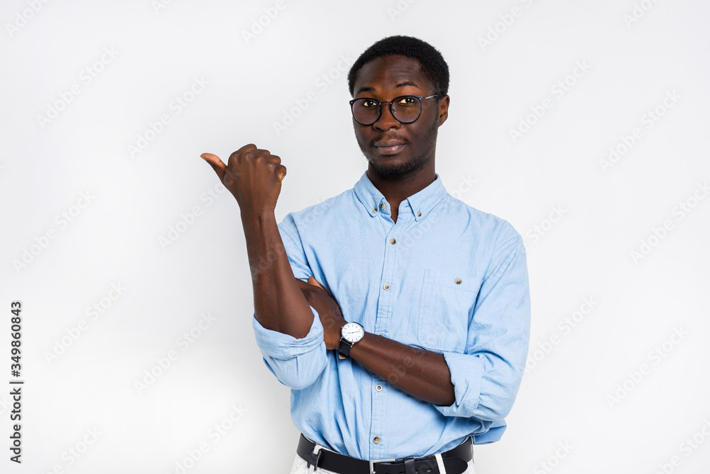 Serious handsome african man in glasses points with his finger on isolated white background Serious handsome african man in glasses points with his finger on isolated white background