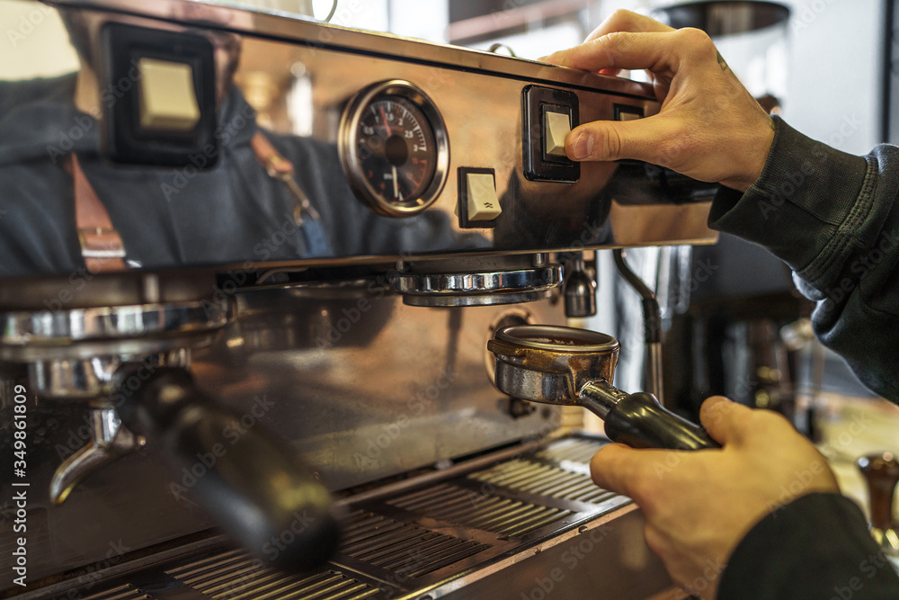 Barista preparing professional coffee machine to work