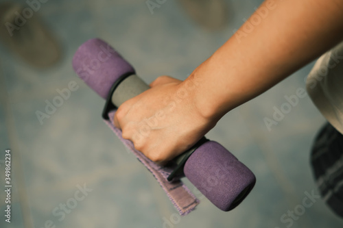 Unrecognized woman workout at home with Dumbbells medium closeup shot