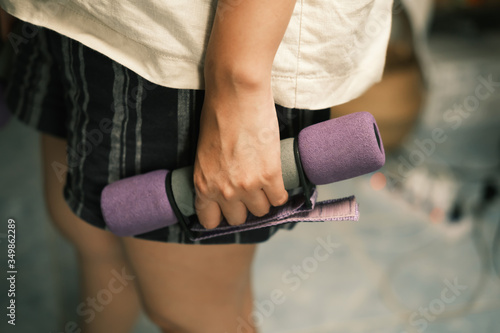 Unrecognized woman workout at home with Dumbbells medium closeup shot