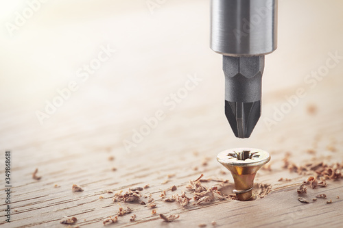 screwdriver screw in a wood oaks plank photo