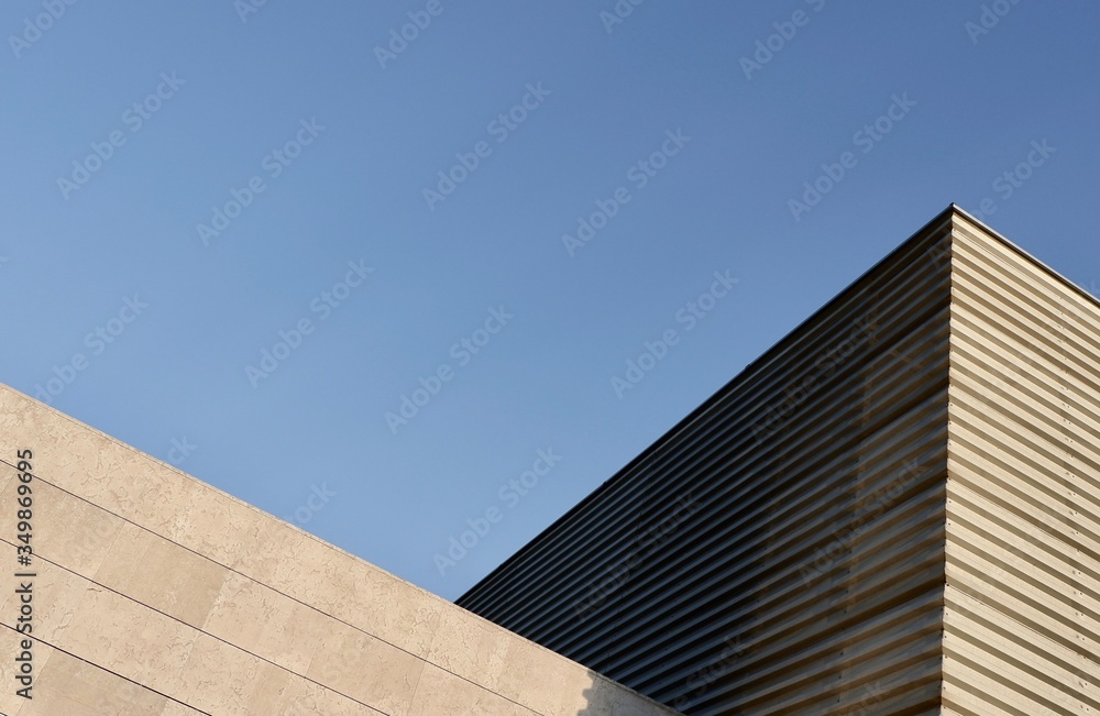 Triangle side corner of wide minimal building backlit by sun in suburban district Triangle side corner of wide minimal building backlit by sun in suburban district