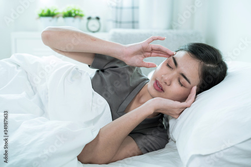 An Asian woman wakes up early with a headache, dizziness, Migraine, Tension.
