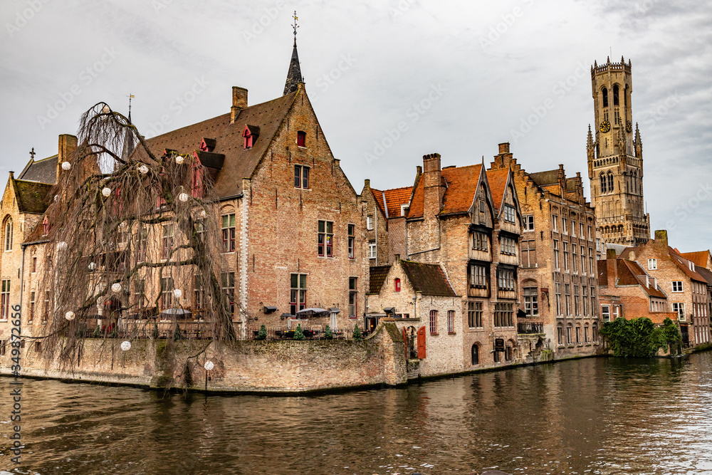 Buildings around channels and clock tower in Bruges
