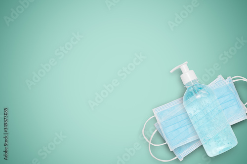 Isolated white Surgical face mask and alcohol gel for protection Corona virus or COVID 19 and dust PM 2.5 on green background . Healthcare and hygiene equipment concept. Photo include clipping path.