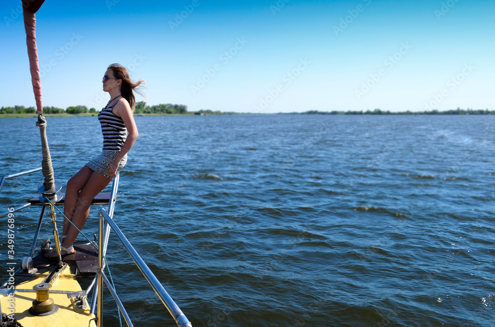 Girl on a yacht sailing along the Dnieper River. Strong wind.
