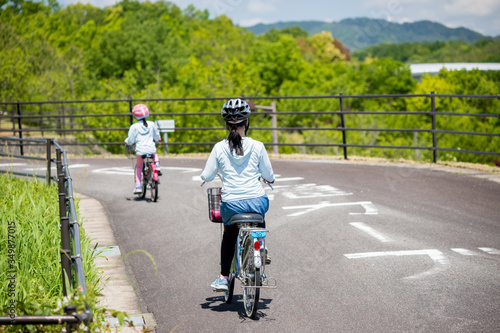 夏の公園で自転車を乗っている子供姉妹