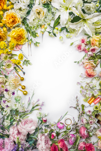Top view of round frame with decoration artificial flowers  branches  leaves  petals  instruments and paint. isolated on white background.  