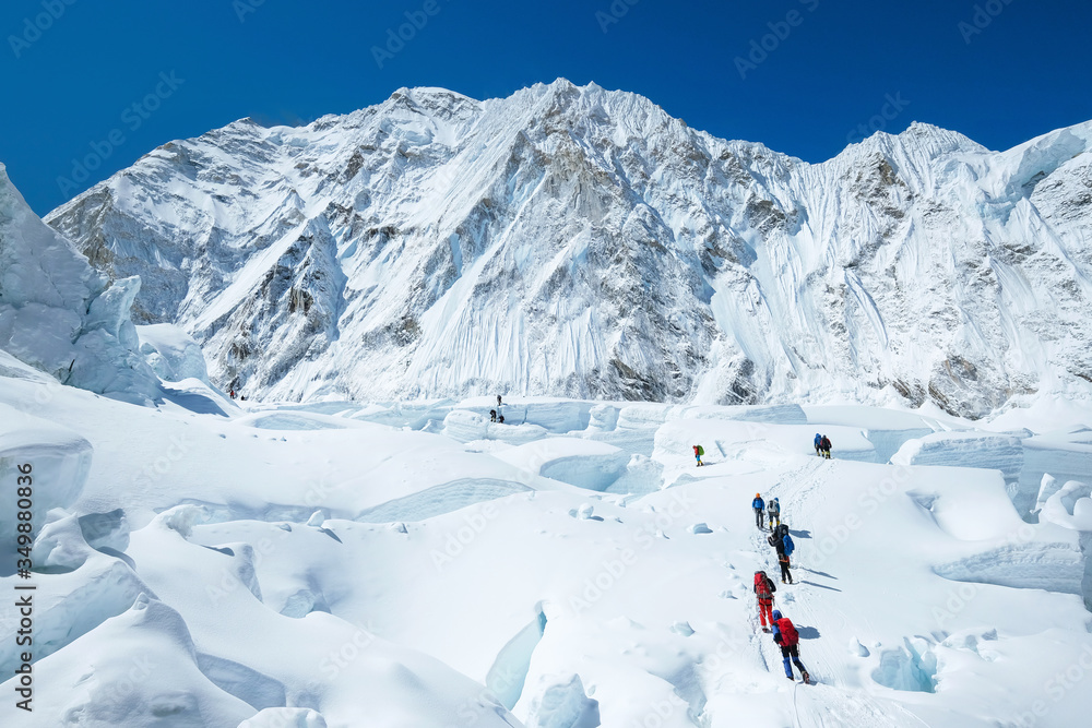 Goup of climbers reaching the Everest summit in Nepal. Team work concept.