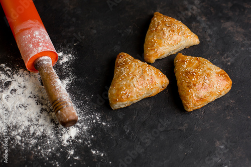 Asian cuisine. Homemade samsa with chicken, sesame and greens on a dark background. Top view side View. Space for text