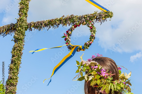Mit Blumenkranz am Mittsommerbaum in Schweden