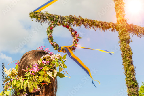 Mit Blumenkranz am Mittsommerbaum in Schweden