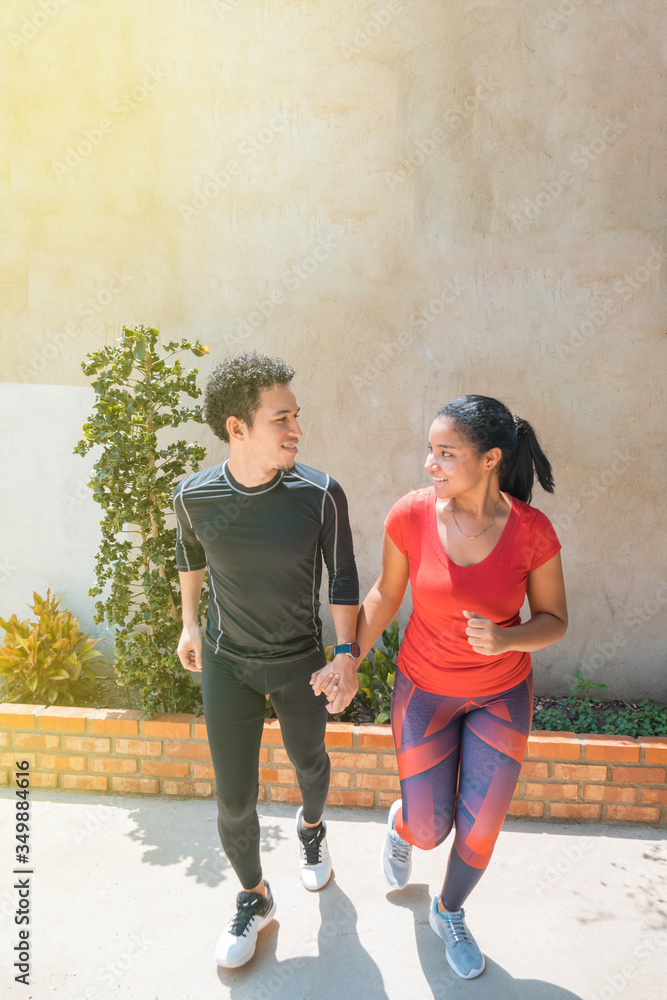 Portrait of a young couple running home in the morning. Concept of sport and love. Warm tone.