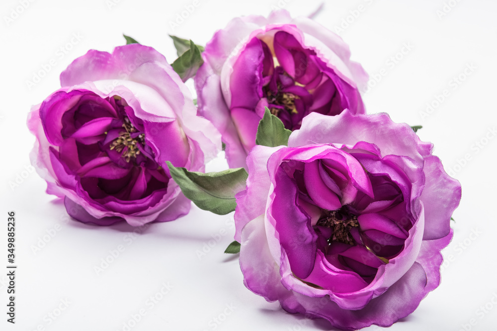 Artificial purple roses on white background Artificial purple roses on white background