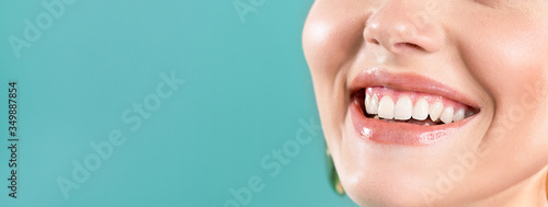 Laughing woman mouth with big teeth on a blue background. Healthy white teeth. Broad smile. Oral care.