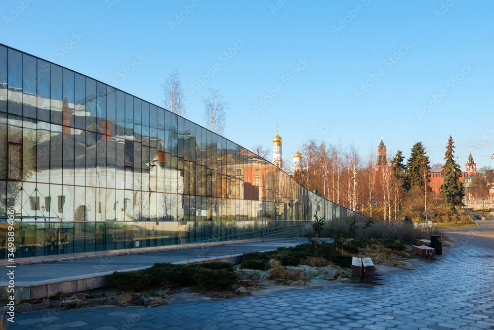 Fototapeta premium The Zaryadye Park. Varvarka Street. The Varvarinskaya Church, the old English courtyard and the Moscow Kremlin reflected in a glass facade of the house 6, Building 1