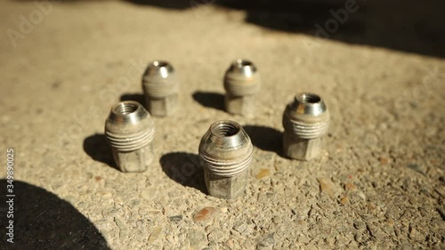 Showing car wheel screws lying on the road with flying camera