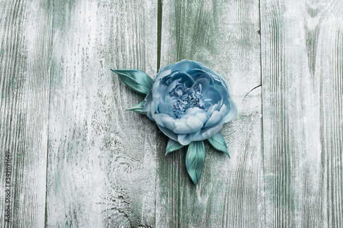 Blue artificial peonies on green wood table 