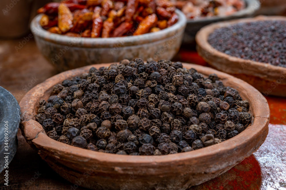Indian spices collection, dried black peppercorns and another spices in clay bowls Indian spices collection, dried black peppercorns and another spices in clay bowls