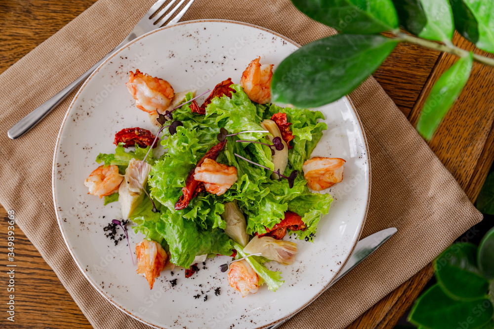 light healthy salad of fresh vegetables and shrimp. Photo in the interior light healthy salad of fresh vegetables and shrimp. Photo in the interior