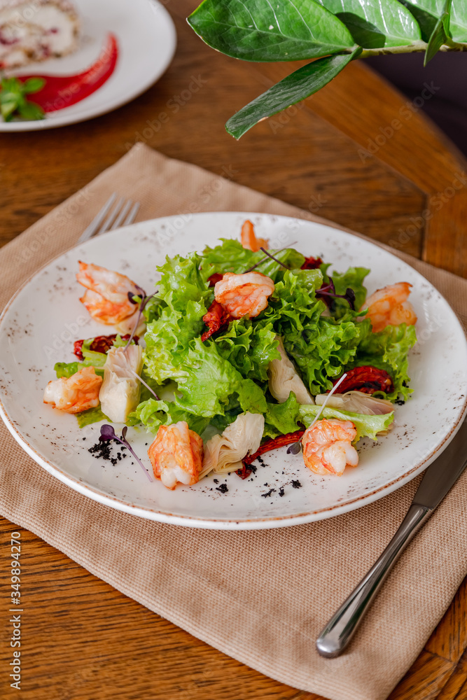 light healthy salad of fresh vegetables and shrimp. Photo in the interior light healthy salad of fresh vegetables and shrimp. Photo in the interior