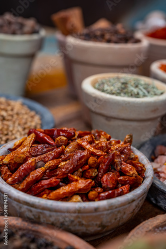Indian spices collection, dried red hot chili peppers and another spices in clay bowls