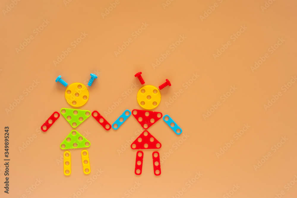 Female figures made of build and design mosaic puzzles on beige background with copy space.