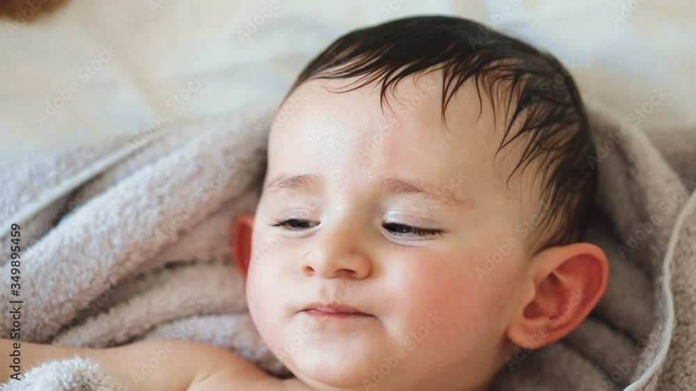Close up of nice caucasian newborn baby on the bed and sucking a pacifier Close up of nice caucasian newborn baby on the bed and sucking a pacifier