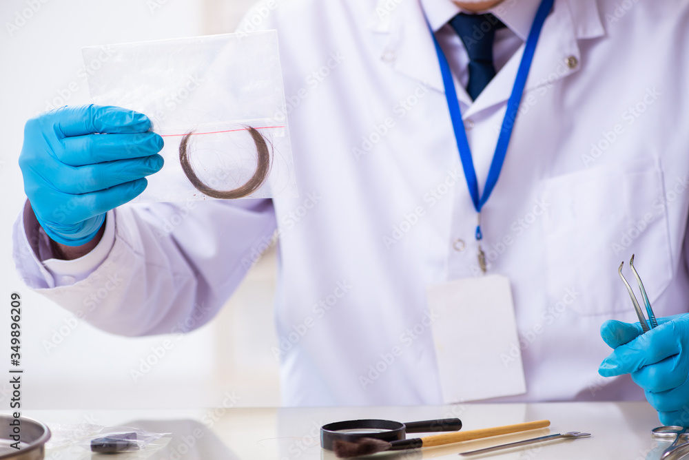 Old male expert criminologist working in the lab for evidence Old male expert criminologist working in the lab for evidence