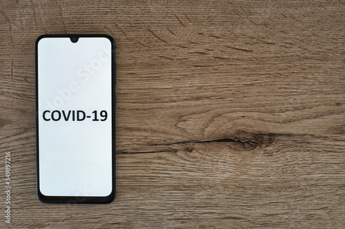Mobile phone displaying covid-19 on the desk