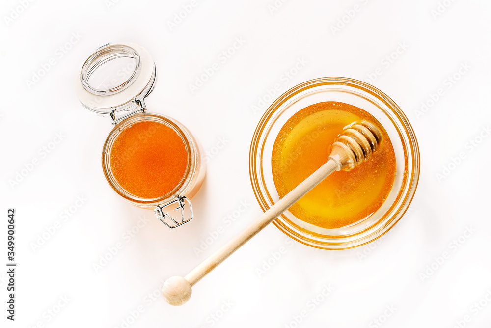Glass jar and saucer with honey and a spoon for honey isolated on white background. Glass jar and saucer with honey and a spoon for honey isolated on white background.